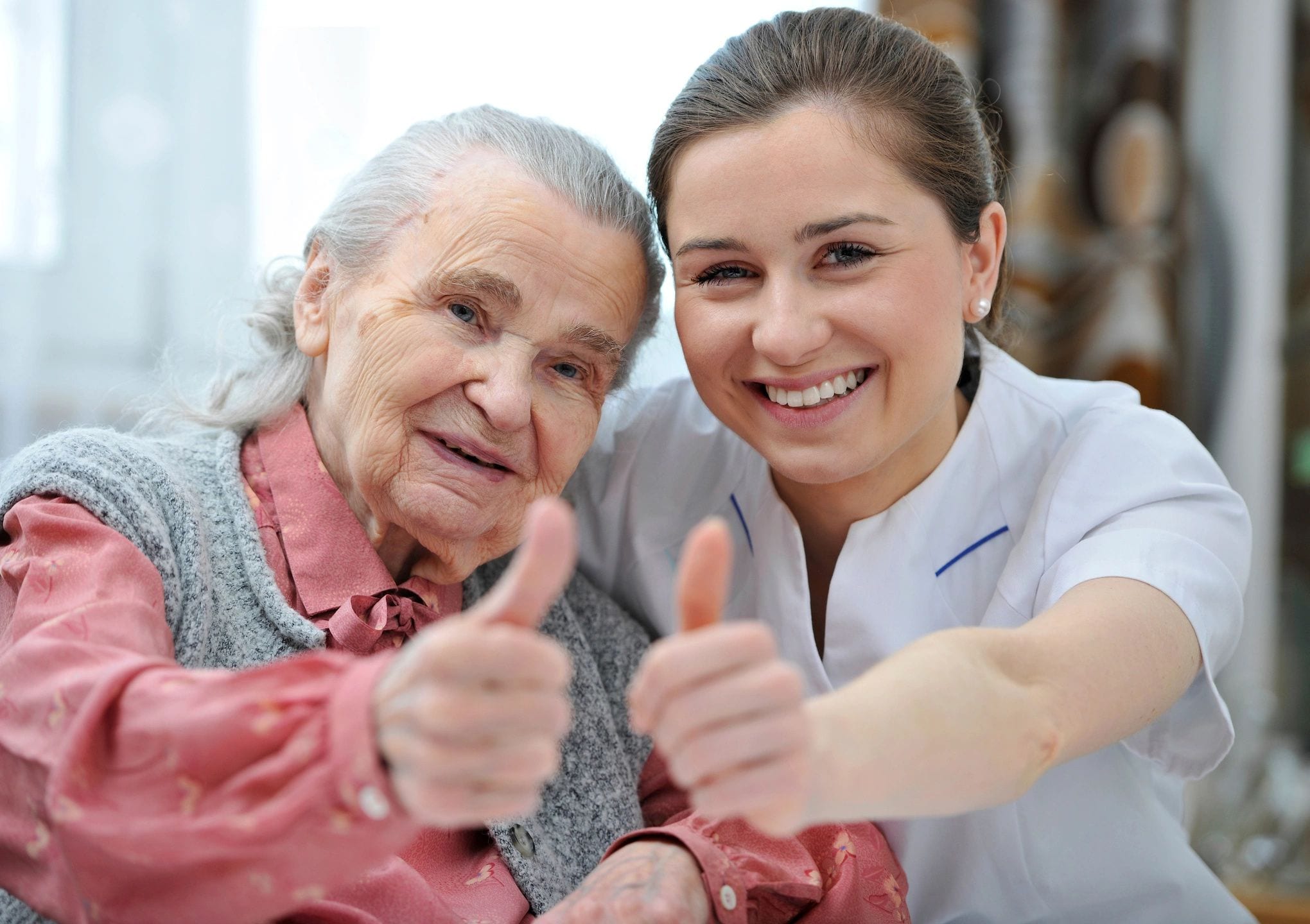 A woman and an old lady giving thumbs up